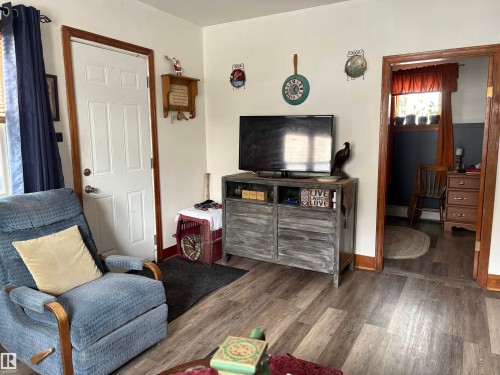 This living area features light-colored walls and wood-look flooring - 5117 52 Avenue, Elk Point, AB - Indoor
