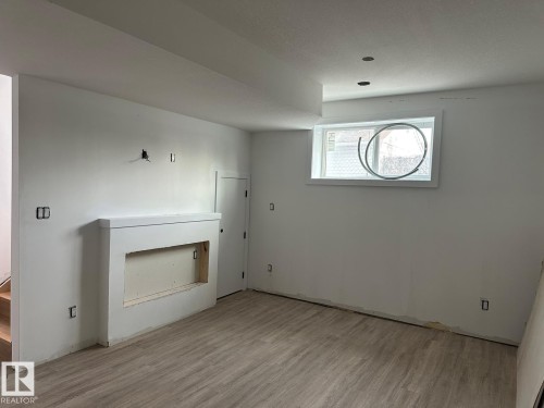 Living area featuring a window, recessed lighting, a fireplace surround, and wood-look flooring - 9214 152 Street, Edmonton, AB - Indoor Photo Showing Other Room