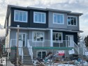 This property features a contemporary exterior with light grey and dark grey siding, white window trim, and white railings on the front porches - 9214 152 Street, Edmonton, AB  - Outdoor With Facade 