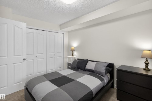 Bedroom featuring light-colored walls and carpeted flooring - 311 12035 22 Avenue, Edmonton, AB - Indoor Photo Showing Bedroom