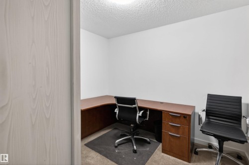 This property features a dedicated room with light-colored walls and carpeting, offering a versatile space - 311 12035 22 Avenue, Edmonton, AB - Indoor Photo Showing Office