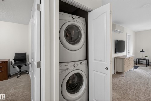 In-unit stacked washer and dryer for convenience - 311 12035 22 Avenue, Edmonton, AB - Indoor Photo Showing Laundry Room