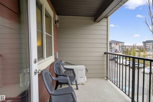 The property features a private outdoor balcony with a black metal railing and a view of the surrounding neighborhood - 311 12035 22 Avenue, Edmonton, AB - Outdoor With Balcony With Exterior
