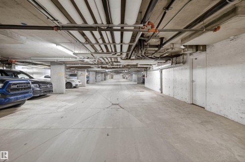 Secure underground parking garage with concrete walls and pillars - 311 12035 22 Avenue, Edmonton, AB - Indoor Photo Showing Garage
