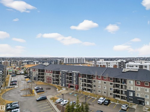 This property features multi-story buildings with balconies, visible parking areas, and dark roofs - 311 12035 22 Avenue, Edmonton, AB - Outdoor With View