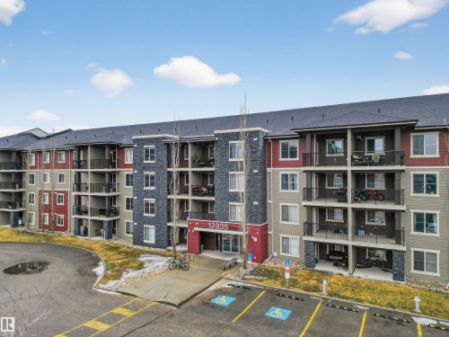 The property features a multi-story building with a dark roof and balconies - 311 12035 22 Avenue, Edmonton, AB - Outdoor With Balcony With Facade