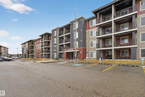 Multi-story apartment building with balconies, featuring varied exterior siding and stone accents - 311 12035 22 Avenue, Edmonton, AB - Outdoor With Balcony With Facade