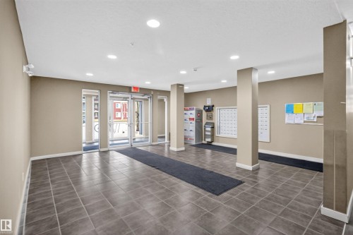 Entrance lobby featuring tiled flooring, recessed lighting, and glass double doors - 311 12035 22 Avenue, Edmonton, AB - Indoor Photo Showing Other Room