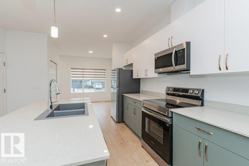 The kitchen features a double basin sink, stainless steel appliances, and a light-colored countertop - 9652 Colak Link Link, Edmonton, AB - Indoor Photo Showing Kitchen With Double Sink