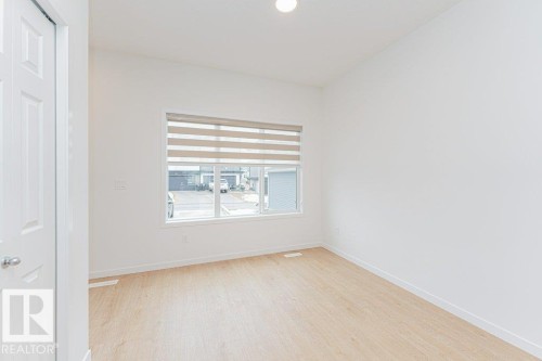 This room features light-colored flooring and white walls, creating a bright and airy atmosphere - 9652 Colak Link Link, Edmonton, AB - Indoor Photo Showing Other Room