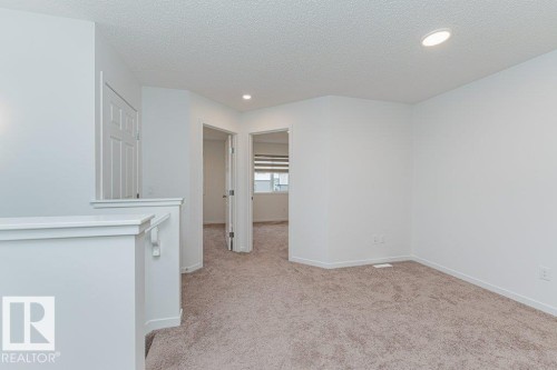 This versatile area features carpet flooring, recessed lighting, and a neutral color palette - 9652 Colak Link Link, Edmonton, AB - Indoor Photo Showing Other Room