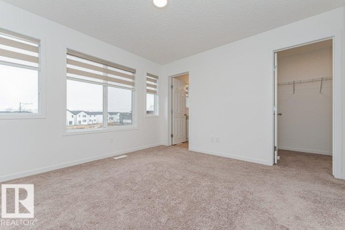 This room features light-colored carpet, white walls, and multiple windows with blinds - 9652 Colak Link Link, Edmonton, AB - Indoor Photo Showing Other Room