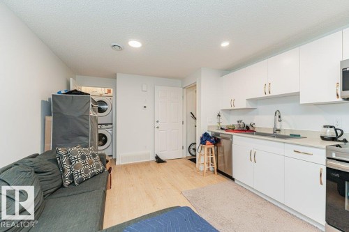 The property features a kitchen with white cabinetry, a stainless steel dishwasher, and a sink with a modern faucet - 9652 Colak Link Link, Edmonton, AB - Indoor Photo Showing Kitchen With Double Sink