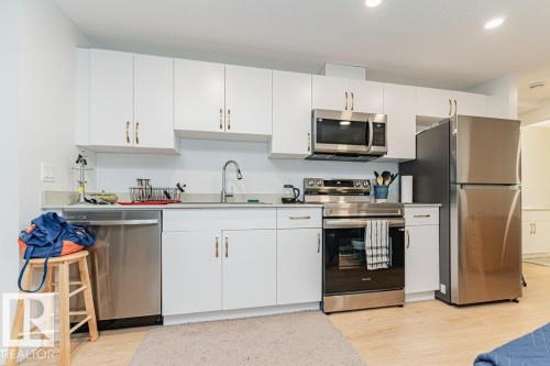 The kitchen features white cabinetry, stainless steel appliances, and a light-colored countertop - 9652 Colak Link Link, Edmonton, AB - Indoor Photo Showing Kitchen