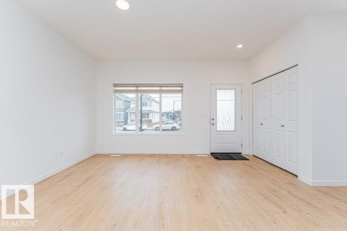 Bright and airy interior featuring light-colored flooring, white walls, and a large window providing natural light - 9652 Colak Link Link, Edmonton, AB - Indoor Photo Showing Other Room