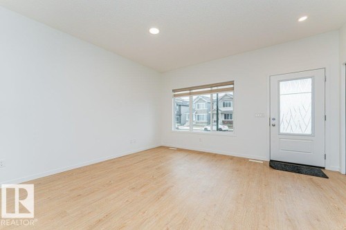 Inviting entry space featuring light-toned flooring, white walls, and a window providing natural light - 9652 Colak Link Link, Edmonton, AB - Indoor Photo Showing Other Room