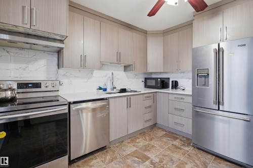 Well-appointed kitchen featuring light-colored cabinetry, a white countertop, and stainless steel appliances - 16049 95 Avenue, Edmonton, AB - Indoor Photo Showing Kitchen