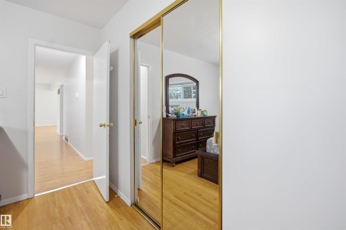 The property features light wood flooring throughout the hallway and into the visible interior rooms - 16049 95 Avenue, Edmonton, AB - Indoor Photo Showing Other Room