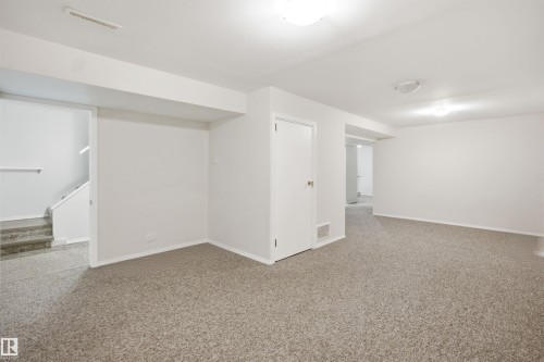 Spacious room featuring light-colored carpet, white painted walls, and overhead lighting - 16049 95 Avenue, Edmonton, AB - Indoor Photo Showing Other Room