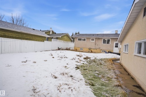 The property features a spacious yard with a white privacy fence - 16049 95 Avenue, Edmonton, AB - Outdoor With Exterior