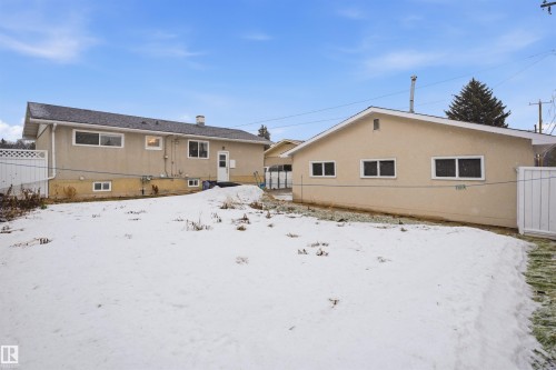 The property features a stucco exterior, a dark shingle roof, and multiple windows - 16049 95 Avenue, Edmonton, AB - Outdoor With Exterior