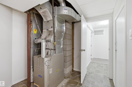 Utility area featuring a furnace and ductwork, with a tiled floor and painted walls - 16049 95 Avenue, Edmonton, AB - Indoor