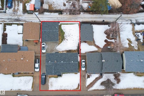 Aerial view of the property, featuring two buildings with dark-shingled roofs, private driveways, and surrounding green spaces - 16049 95 Avenue, Edmonton, AB - Outdoor