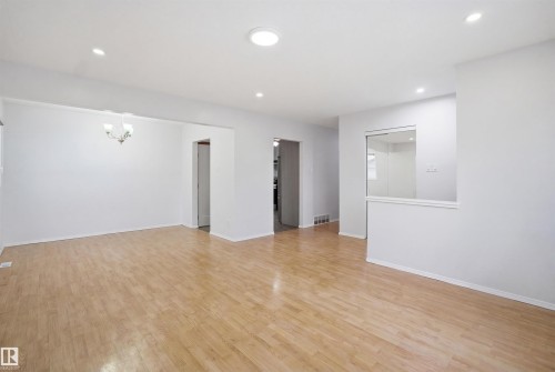 This spacious room features light wood flooring and recessed lighting, creating a bright and inviting atmosphere - 16049 95 Avenue, Edmonton, AB - Indoor Photo Showing Other Room