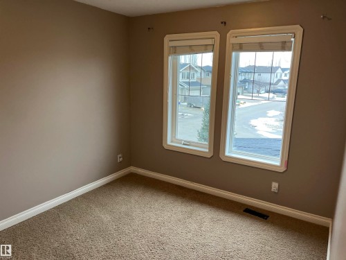 The room features two windows with blinds, offering natural light - 21917 95A Avenue, Edmonton, AB - Indoor Photo Showing Other Room