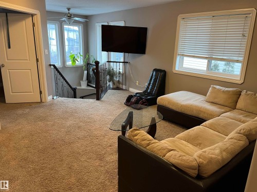 Living area featuring carpeted flooring, a ceiling fan, and windows with blinds - 21917 95A Avenue, Edmonton, AB - Indoor