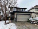 The property features a two-story exterior with light-colored siding, dark trim, and stone accents - 21917 95A Avenue, Edmonton, AB  - Outdoor 
