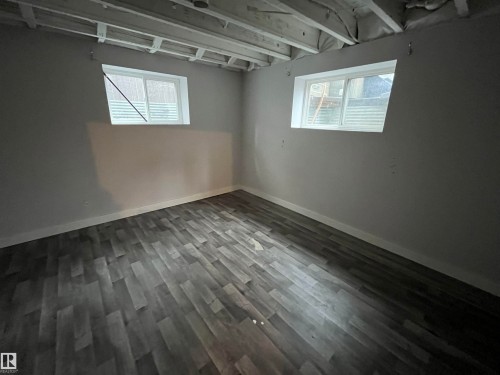 Room featuring two windows, gray walls, and wood-look flooring - 21917 95A Avenue, Edmonton, AB - Indoor Photo Showing Other Room
