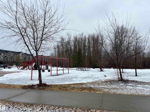This property is located near a park area featuring a red playground structure with swings and a slide - 21917 95A Avenue, Edmonton, AB - Outdoor With View