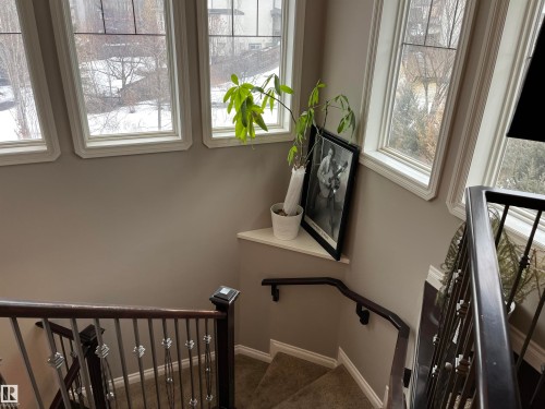 This property features a staircase with dark wood handrails and decorative metal balusters - 21917 95A Avenue, Edmonton, AB - Indoor Photo Showing Other Room