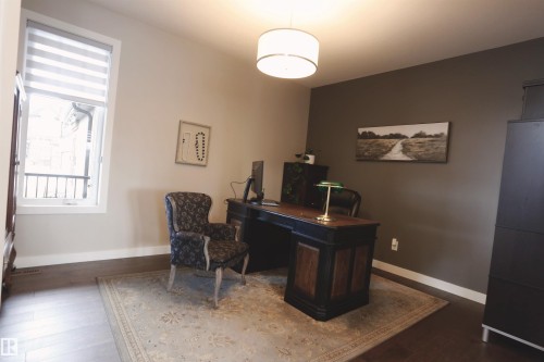 This room features wood flooring, a window with horizontal blinds, and a drum pendant light fixture - 1003 Huckell Place, Edmonton, AB - Indoor Photo Showing Office
