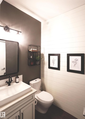 This bathroom features a contemporary vanity with an integrated rectangular sink and a dark-toned faucet - 1003 Huckell Place, Edmonton, AB - Indoor Photo Showing Bathroom