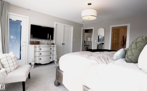 This bedroom features light grey walls and light grey carpeting, creating a serene ambiance - 1003 Huckell Place, Edmonton, AB - Indoor Photo Showing Bedroom