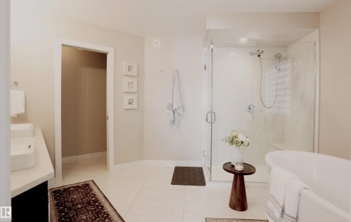Bathroom featuring a freestanding bathtub, a walk-in shower with a glass enclosure, and a vanity with dual vessel sinks - 1003 Huckell Place, Edmonton, AB - Indoor Photo Showing Bathroom