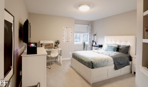 This room features light-colored walls, carpeted flooring, and a window with blinds and curtains - 1003 Huckell Place, Edmonton, AB - Indoor Photo Showing Bedroom