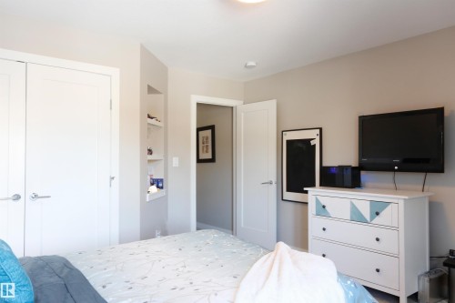 This interior offers light-colored walls, white doors with modern handles, and an open doorway leading to an additional interior space - 1003 Huckell Place, Edmonton, AB - Indoor Photo Showing Bedroom