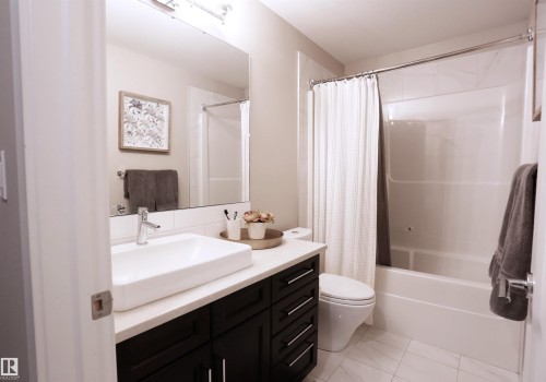 Bathroom featuring a contemporary vanity with a rectangular vessel sink, a white countertop, and a large mirror - 1003 Huckell Place, Edmonton, AB - Indoor Photo Showing Bathroom