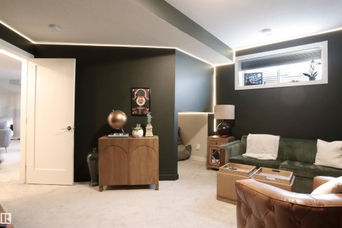 Spacious living area featuring dark walls, recessed lighting, and a window for natural light - 1003 Huckell Place, Edmonton, AB - Indoor