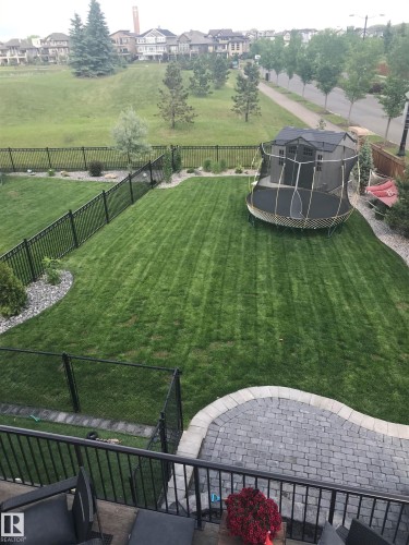 The property features an extensive backyard with a well-maintained lawn and a paved patio area - 1003 Huckell Place, Edmonton, AB - Outdoor