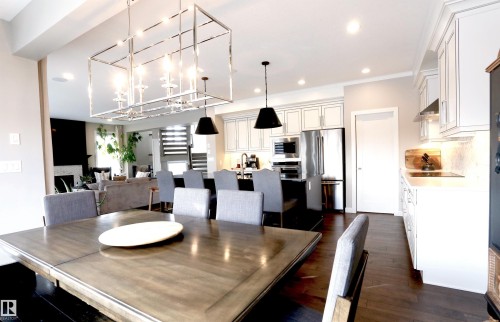 Open concept living area with dark hardwood flooring, a modern chandelier, and recessed lighting - 1003 Huckell Place, Edmonton, AB - Indoor Photo Showing Other Room