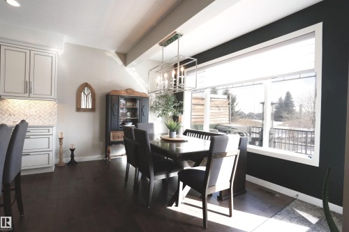 Dining area featuring hardwood floors, a large window providing natural light, and a modern light fixture - 1003 Huckell Place, Edmonton, AB - Indoor Photo Showing Dining Room
