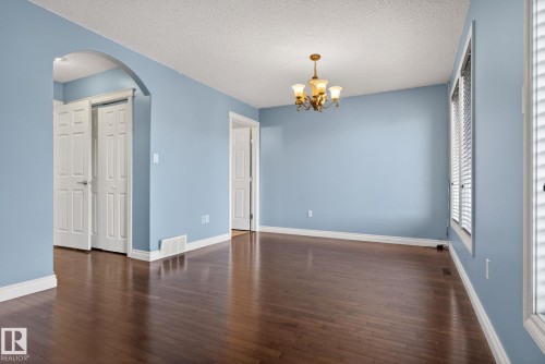The property features hardwood floors, light blue walls, and white trim throughout - 10418 69 Avenue, Edmonton, AB - Indoor Photo Showing Other Room