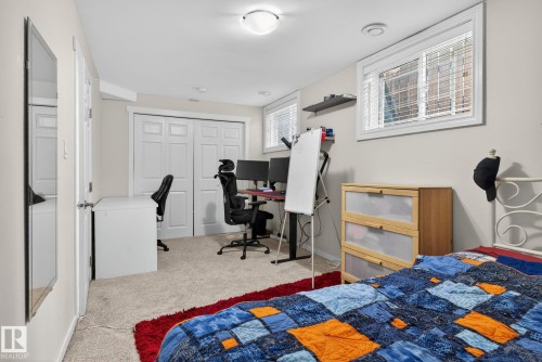 The room features light-colored walls, carpeted flooring, and a window with blinds - 10418 69 Avenue, Edmonton, AB - Indoor Photo Showing Bedroom