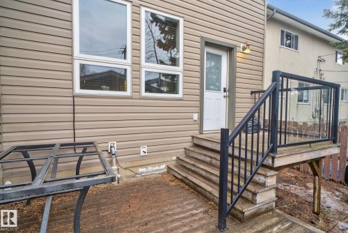 Rear exterior of the property featuring horizontal siding and multiple windows - 10418 69 Avenue, Edmonton, AB - Outdoor With Exterior