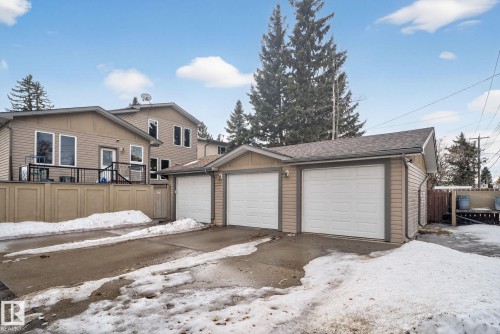 The property features a triple-car garage with white garage doors and an asphalt driveway - 10418 69 Avenue, Edmonton, AB - Outdoor