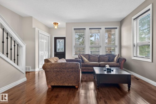 The property features rich hardwood flooring throughout the main living areas - 10418 69 Avenue, Edmonton, AB - Indoor Photo Showing Living Room